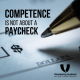 pen and blank check with text competence is not about a paycheck