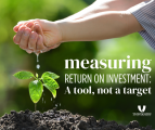 outstretched hands pour water into growing seedling