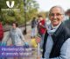 smiling older woman holding a rake volunteering at a clean up on the beach