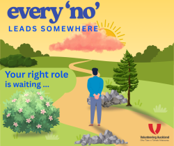 person looking into distance on a winding path toward a sunset