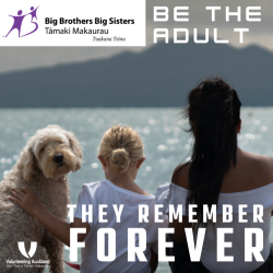 A female adult and child with a dog sitting looking towards rangitoto island