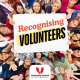 A crown of people looking up at a sign saying recognising volunteers