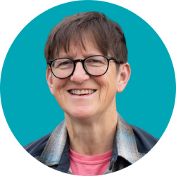 Head shot of a smiling woman wearing glasses with short dark hair