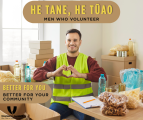 A man smiling among boxes of donations